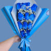 Vivid blue roses take center stage in this blue-and-white hand-tied bouquet, a