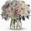 Soft pink roses, creamy white lilies, and pale lavender hydrangeas mingle in