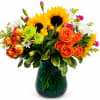 Sunset Sunflower Delight combines golden sunflowers, orange roses, and seasonal blooms in