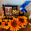 A vibrant celebratory crate featuring bright sunflowers, a "Greatest Dad Ever" glass