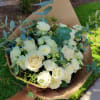Bouquet of white roses with eucalyptus wrapped in brown paper