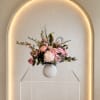 Beautiful flowers in soft pinks and whites in a rounded ceramic vase