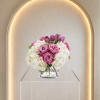 Pink roses ring the center of this compact, rounded bouquet, with soft