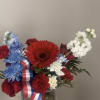 A bold red gerbera daisy crowns this patriotic bouquet, the first thing