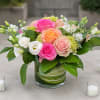 Soft pink, hot pink, and peach roses, along with green hydrangea, white