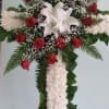 Cross-shaped floral tribute with red roses and white lilies