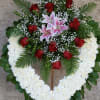 Heart-shaped floral wreath with red roses, pink lilies, and white flowers