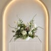 A airy asymmetrical arrangement with soft accent blooms in a white ceramic