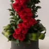Tall arrangement of red roses in a black hat box