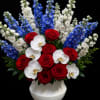 A striking mix of Phalaenopsis orchids, roses and delphinium creates a dramatic