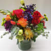 Colorful mixed bouquet in a glass vase with roses and assorted blooms