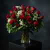 A luxurious arrangement of thirty premium red roses accented with delicate Queen