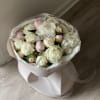 Bouquet of white and pale pink peonies wrapped in blush paper