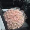 Large bouquet of pale pink roses wrapped in translucent paper