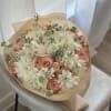 Bouquet of white and peach flowers wrapped in beige paper