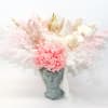 Pink and white dried floral arrangement in a sculpted face vase