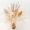Cream roses in a copper vase with dried pampas grass and white fern-like foliage