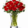 Red roses arranged in a clear glass vase with baby's breath
