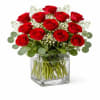 Red roses arranged in a clear square glass vase
