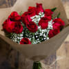 Bouquet of red roses with white baby's breath wrapped in brown paper