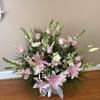 An elegant sympathy arrangement designed with pink stargazer lilies, soft pink roses