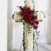 White carnations and red roses are designed into this religious floral display.