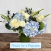 Blue hydrangeas and white roses arranged in a green vase