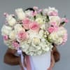 Soft blush and ivory roses gathered with clouds of white hydrangea create