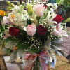 Bouquet of red and pink roses with white lilies in a glass vase