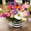 A lively, low centerpiece built around a striking white anemone-this mixed-color bouquet
