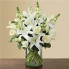 White lilies and roses arranged in a clear glass vase