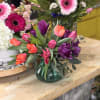 A joyful, spring-ready bouquet built around a dense cluster of tulips-this flower