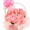 A compact cluster of soft pink roses tucked into a woven basket
