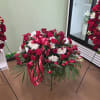 Deep red roses and pure white blooms form a dignified, romantic tribute