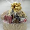 Gift basket with bottles and boxed treats wrapped in clear cellophane and a gold bow