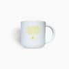 White mug with yellow text and a small logo