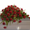 A broad spray of deep red carnations arranged with lush greenery creates