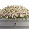 A soft, layered casket spray that speaks to gentle remembrance-this flower arrangement
