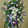 An arrangement consisting of white lilies, white roses, white carnations, purple irises