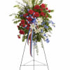 Clusters of deep red carnations and serene white lilies give this standing