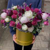 Large bouquet of pink and white flowers in a gold hatbox