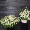 The casket spray features roses,  lilies, and many other blooms. 