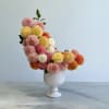 This arrangement is a striking blend of artistry and floristry. Composed almost