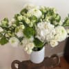 2 foot wide display of white seasonal flowers, spray roses, Hydrangeas, Chrysanthemums