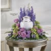 A soft halo of lavender roses and purple carnations frames a white