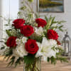 A chorus of vivid red roses and large white lilies creates an