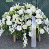 A cascading white casket spray that reads as serene and respectfully formal