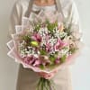 Soft pink lilies take center stage in this romantic bouquet, a perfect