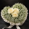 Three cream-white roses sit at the heart of a full, rounded dome