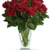 Red roses arranged in a clear glass vase